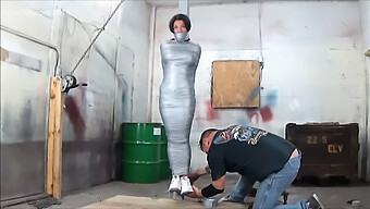 Big-Breasted Woman Restrained With Tape On A Column